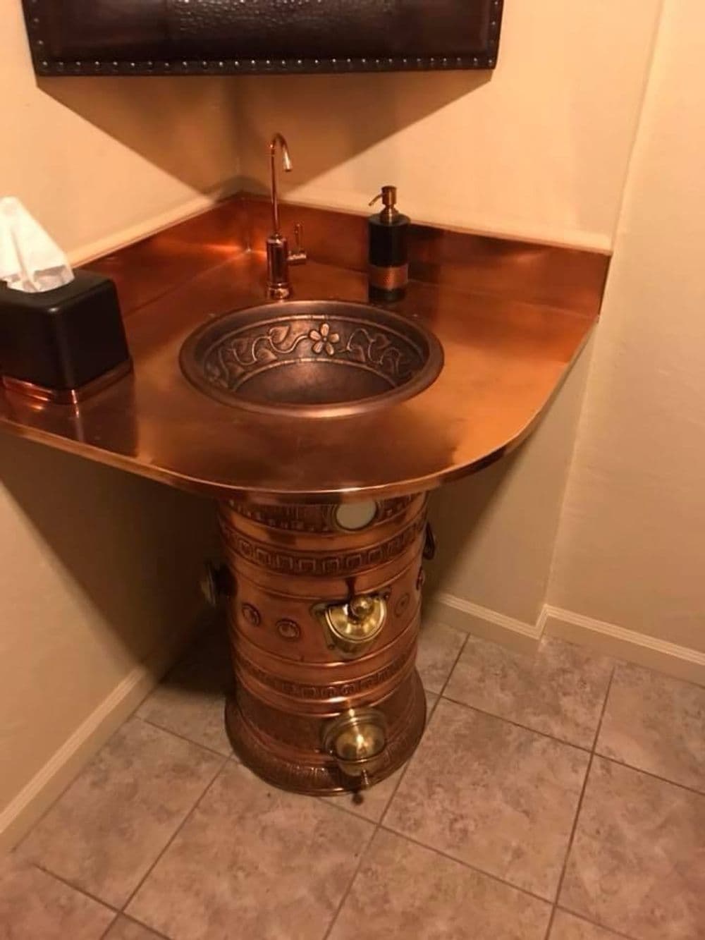 Unique copper sink design with intricate details and matching fixtures in a modern bathroom.